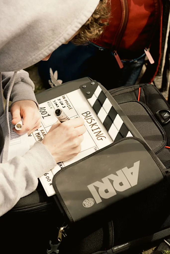 BTS Photography from Irish Short Film "Busking." Gaffer Adam Maher writes a slate.