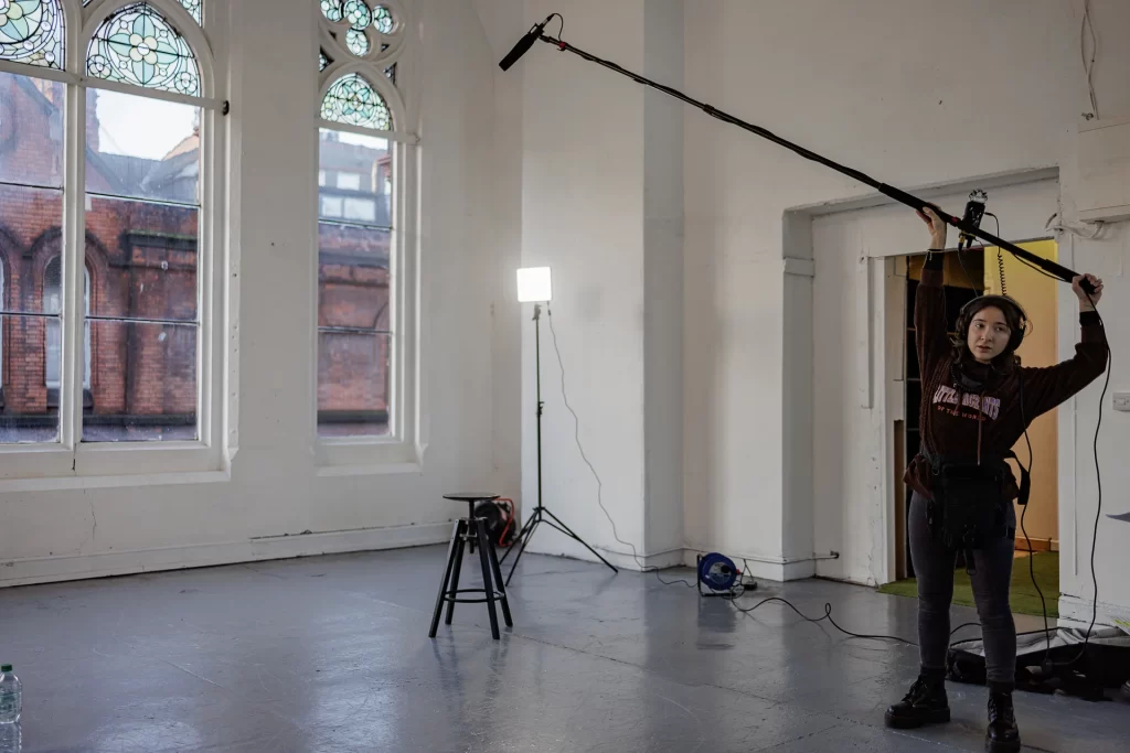 BTS Photograph Unit Stills Photography | "The Painter" | | Short Film Still by Daniel Geesen Unit Stills Photography | "The Painter" | Mariana von Seckendorff holds a boom | Short Film Still by Daniel Geesen