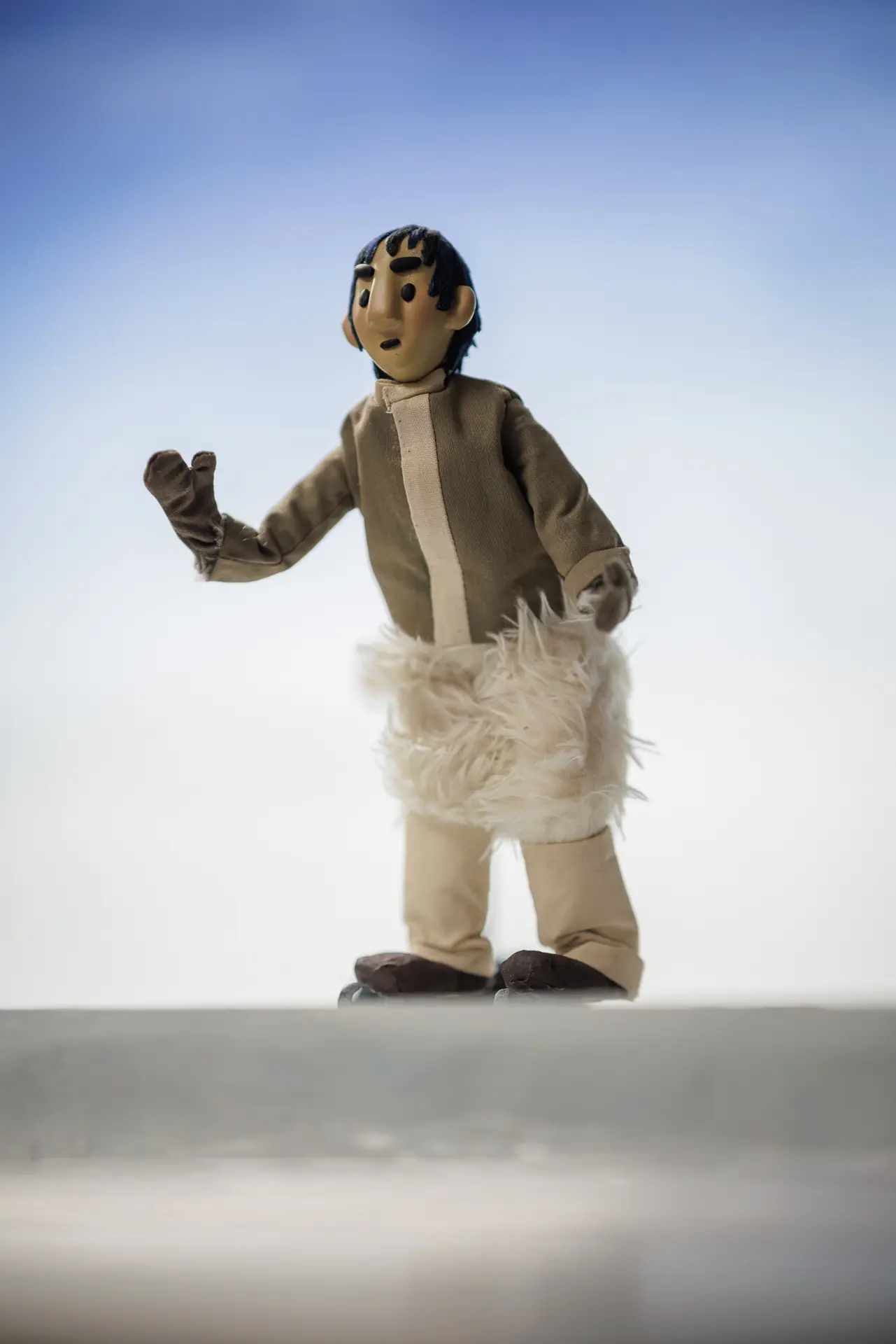 An Inuit teenage boy, Siku, lifts his hand to wave at Kova.