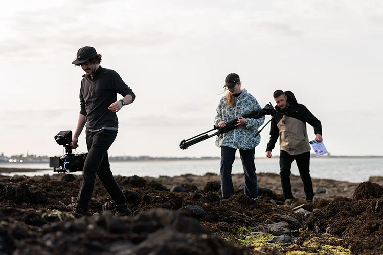 BS of crew traversing rocky shore in "Echoes"